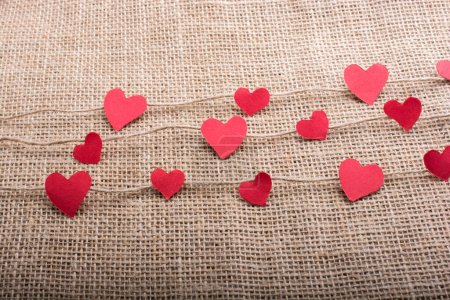 Téléchargez les photos : Concept Love avec des papiers en forme de coeur sur des fils de lin - en image libre de droit