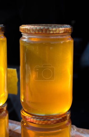 Foto de Tarro de vidrio lleno de miel fresca con tapa - Imagen libre de derechos