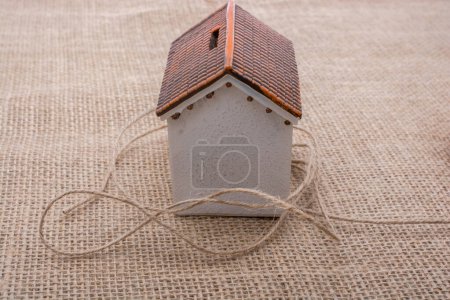 Photo for Thread wrapped around  a model house  on a brown background - Royalty Free Image