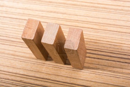Foto de Pieza de elementos dominó de madera sobre textura de madera - Imagen libre de derechos