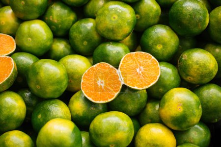 Photo for Freshly picked green tangerines mandarines, clementines, as Citrus fruit background. - Royalty Free Image