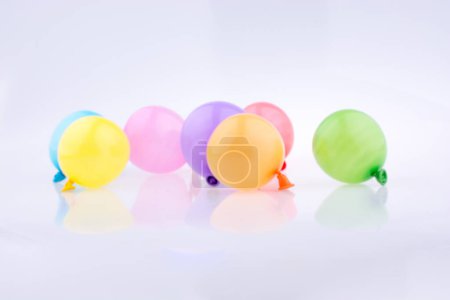 Foto de Pequeños globos de varios colores sobre un fondo blanco - Imagen libre de derechos