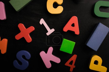Photo for Wooden numbers, letters and blocks on a black background - Royalty Free Image