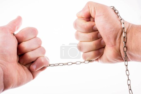 Téléchargez les photos : Homme étirant une fine chaîne dans sa main avec une force sur fond blanc - en image libre de droit