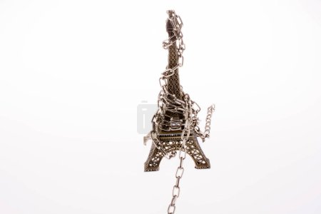 Photo for Little model Eiffel Tower  in chains on a white background - Royalty Free Image