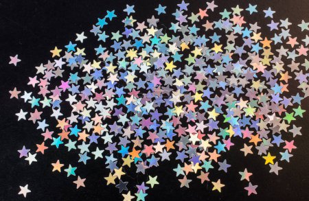 Foto de Coloridas estrellas de confeti sobre un fondo oscuro - Imagen libre de derechos