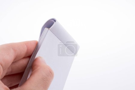Photo for Hand holding white color notebook  on a white background - Royalty Free Image