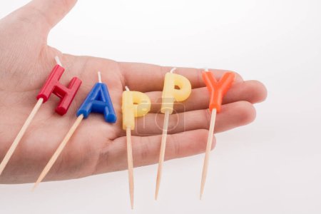 Foto de Las velas de color en los palos escriben la palabra feliz - Imagen libre de derechos