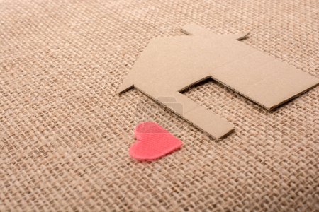 Photo for Heart shape beside paper house with a canvas background - Royalty Free Image
