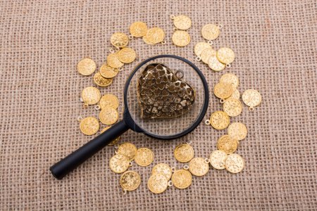 Photo for Fake gold coins around heart shape made of paper - Royalty Free Image