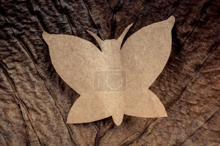 Photo for Butterfly cut of paper on brown paper in view - Royalty Free Image
