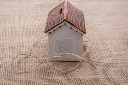 Foto de Hilo envuelto alrededor de una casa modelo sobre un fondo marrón - Imagen libre de derechos
