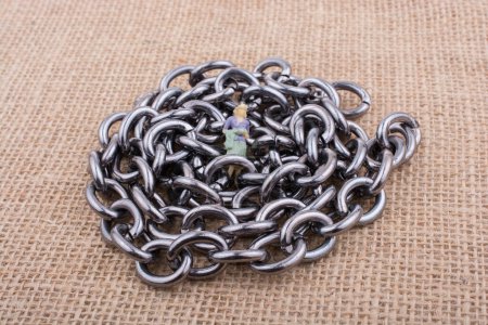Foto de Figura de mujer sobre cadenas de acero sobre una superficie texturizada en exhibición - Imagen libre de derechos
