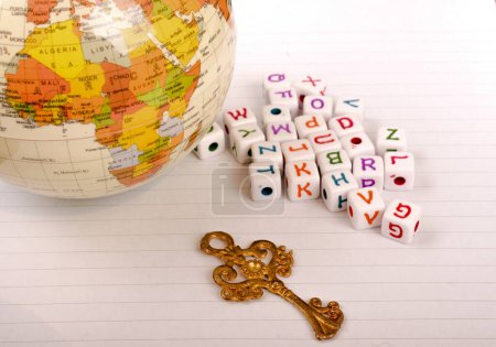 Globus, Schlüssel- und Würfelbuchstaben des Alphabets nebeneinander auf weißem Papier