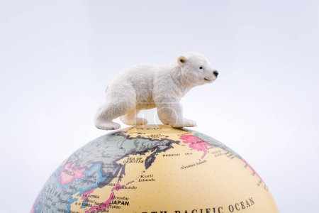 Photo for Polar bear on the top of the globe on white background - Royalty Free Image