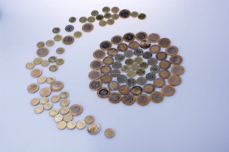 Türkische Lira-Münzen formen einen Halbmond um ein kreisförmiges Objekt auf weißem Hintergrund