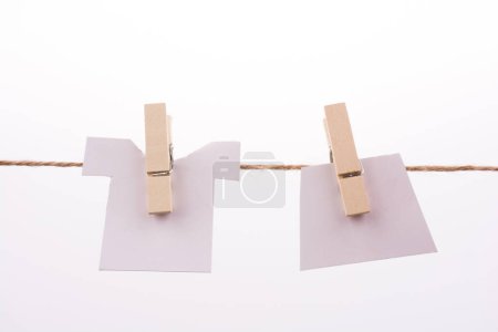 Photo for Clothespins holding clothes on white background - Royalty Free Image