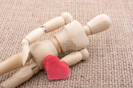 Photo for Heart shaped object  in the hand of a wooden man toy - Royalty Free Image
