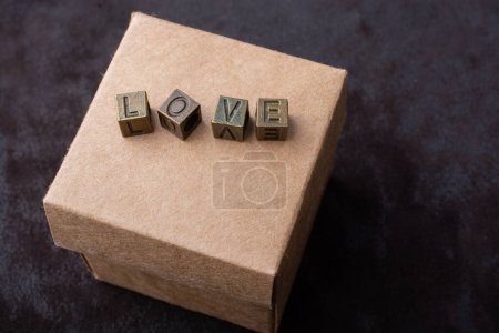 das Wort Liebe mit Metallbuchstaben auf Schachtel als Liebeskonzept