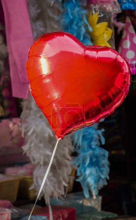 Pequeño globo de color rojo en forma de corazón en un bazar
