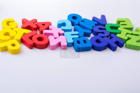 Foto de Bloques de letras de alfabeto coloridos dispersos aleatoriamente sobre fondo blanco - Imagen libre de derechos
