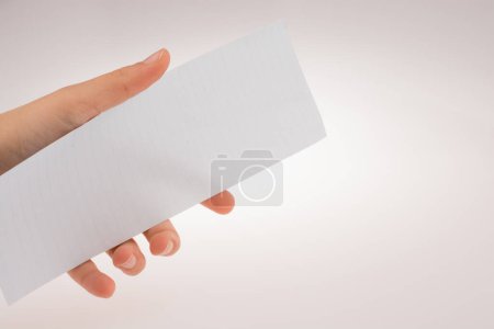 Photo for Hand holding a piece of paper on a white background - Royalty Free Image