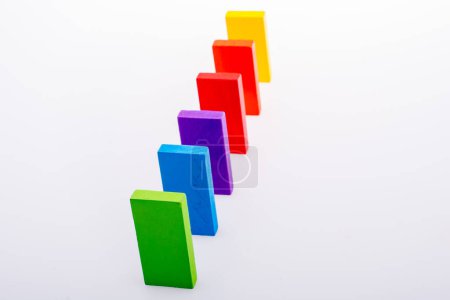 Foto de Bloques de dominó coloridos en una línea sobre un fondo blanco - Imagen libre de derechos