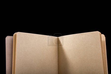 Foto de Cuaderno de color marrón abierto sobre fondo negro - Imagen libre de derechos