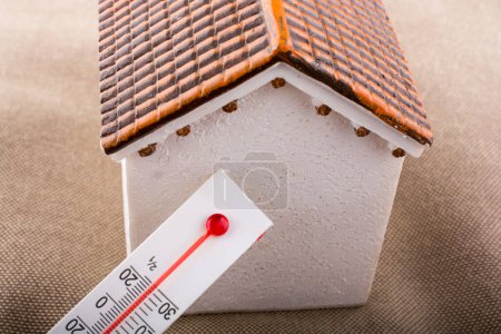 Photo for Thermometer measuring temperature by a little model house - Royalty Free Image