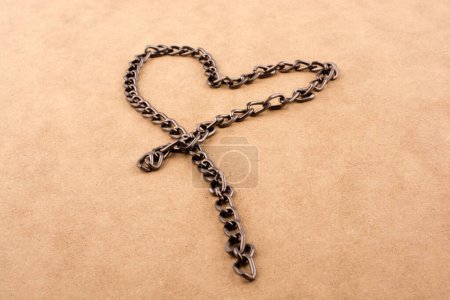 Cadena forma una forma de corazón sobre un fondo marrón
