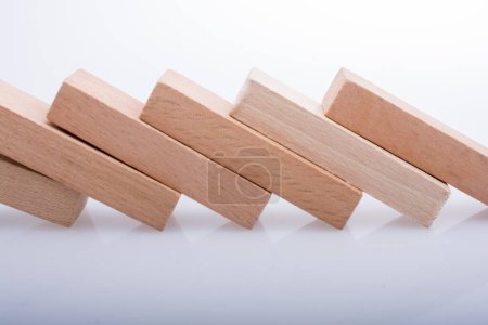 Foto de Bloques de madera Domino en una línea sobre un fondo blanco - Imagen libre de derechos
