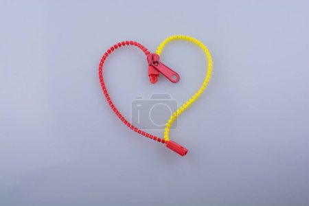 Heart shaped made by the help of a zipper on white background