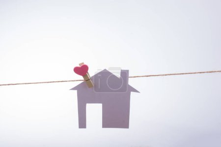 Foto de Pequeña casa de papel unida a una cuerda con un clip para el corazón - Imagen libre de derechos