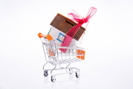Photo for House tied with a red ribbon on a shopping cart - Royalty Free Image