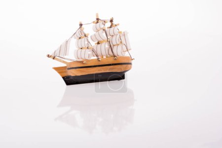 Kleines Modell-Segelboot auf weißem Hintergrund