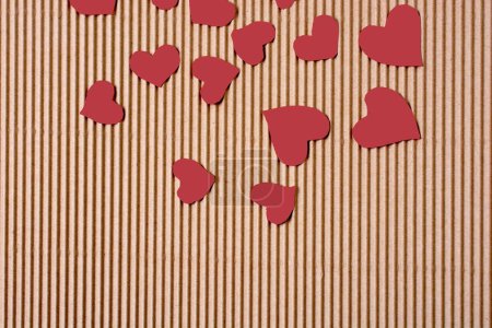 Téléchargez les photos : Coeurs en papier de couleur rouge sur un carton de couleur marron - en image libre de droit