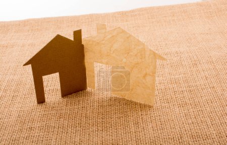 Foto de Pequeña forma de casa cortada de papel sobre un fondo de lona - Imagen libre de derechos
