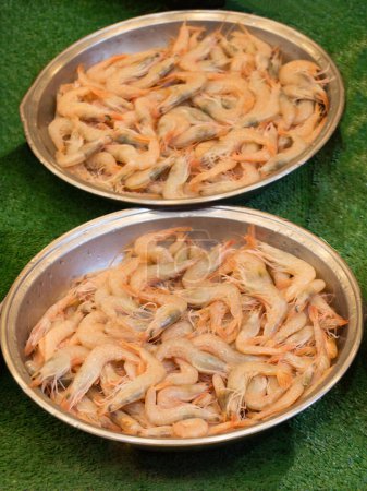 Téléchargez les photos : Des centaines de crevettes fraîches dans des plaques métalliques en vente dans la vue - en image libre de droit