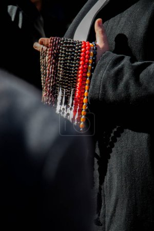 Ensemble de perles de prière de différentes couleurs dans la main dans un marché
