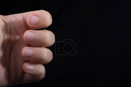 Four fingers of a child hand partly seen in black background