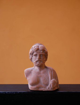 Téléchargez les photos : Reproduction in scale on an orange background of the bust of Zeus or Jupiter (husband of Juno or Hera), supreme god whose symbols are lightning and thunder. - en image libre de droit