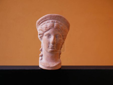 Téléchargez les photos : Scale reproduction on an orange background of the head of Hera or Juno, celestial and lunar divinity, wife of Jupiter or Zeus - en image libre de droit