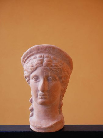 Téléchargez les photos : Scale reproduction on an orange background of the head of Hera or Juno, celestial and lunar divinity, wife of Jupiter or Zeus - en image libre de droit