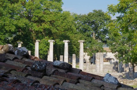 Archäologische Stätte von Altilia: Im Vordergrund das Dach eines Gebäudes und im Hintergrund Reste von Säulen, die darauf hindeuten, wo einst die Basilika stand. Sepino, Molise, Italien