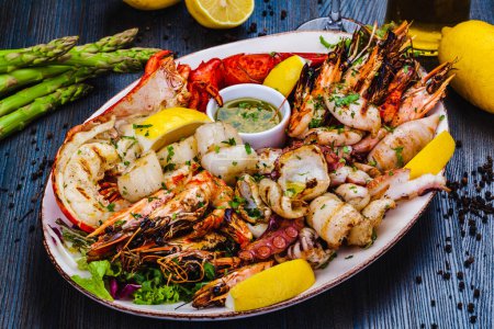 Photo for Seafood platter. Grilled lobster, shrimps, scallops, langoustines, octopus, squid on white plate. - Royalty Free Image