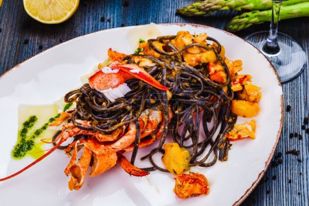 Photo for Squid ink tagliolini with lobster on white plate - Royalty Free Image