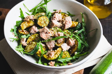 Téléchargez les photos : Fresh salad with arugula, baked zucchini and tuna. the concept of healthy and nutritious food. - en image libre de droit