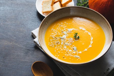 Téléchargez les photos : Soupe de citrouille et de carotte rôtie aux graines de citrouille et de chanvre. Soupe traditionnelle à la citrouille avec texture crémeuse et soyeuse - en image libre de droit