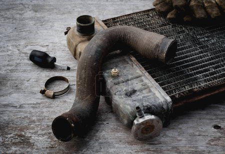 Foto de Radiador de vehículo viejo en mesa de reparación de madera - Imagen libre de derechos