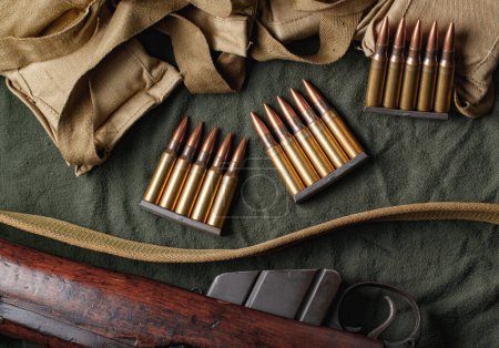 Foto de Pinzas de munición militar y bandoleras con rifle - Imagen libre de derechos